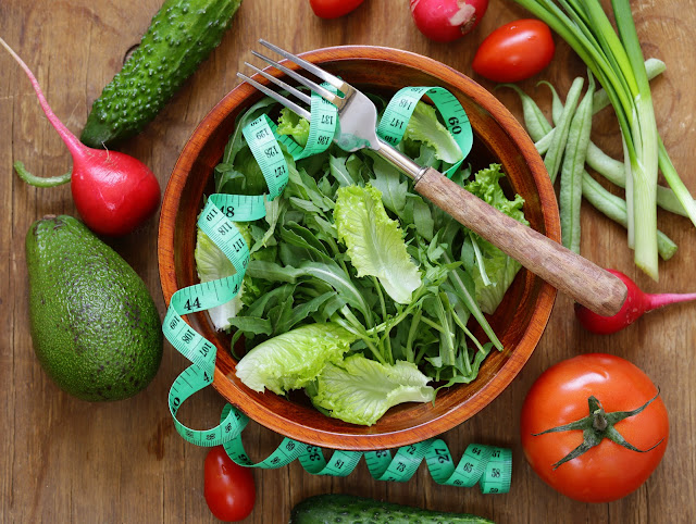 Colorful bowl of vegetables with a measuring tape, perfect for cheap diets to lose weight fast